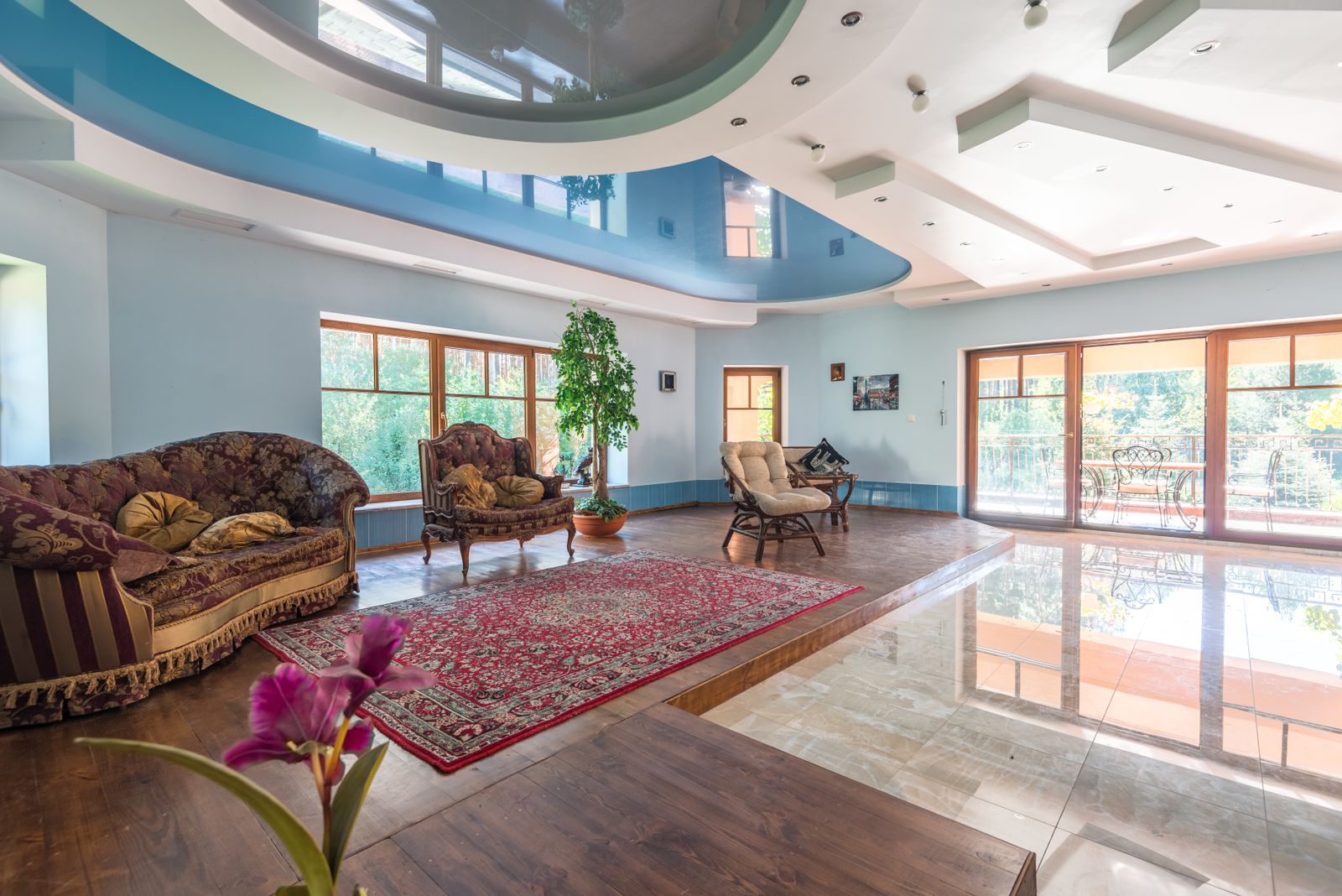 Spacious living room with a bold multi-level finished ceiling and large windows